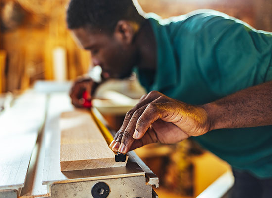 Man preparing to cut wood with tape measure