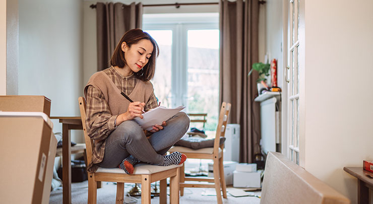 woman at her new home and checking her packing list