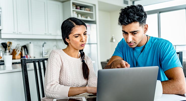 couple using laptop at home