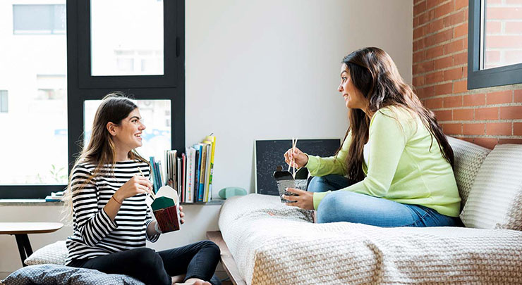 two women having takeout food at home
