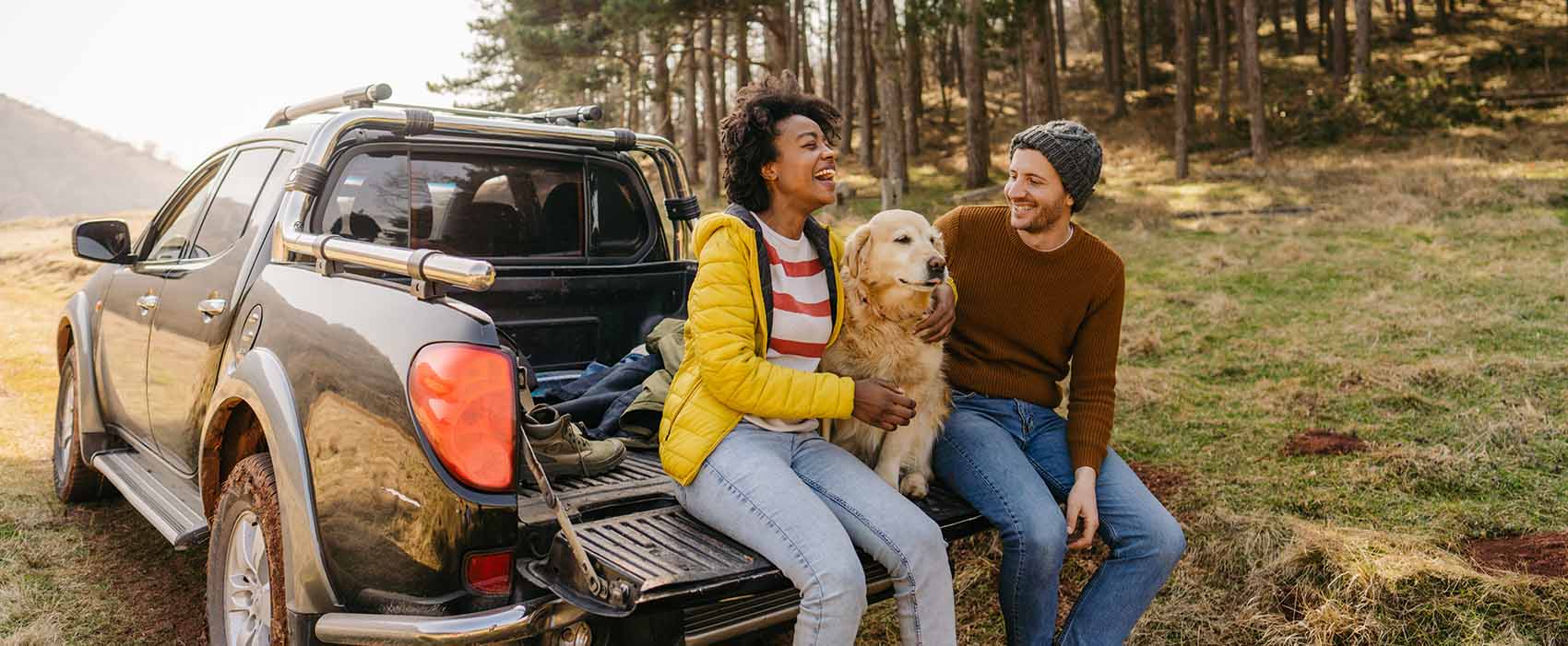 couple sitting on truck bed on road trip