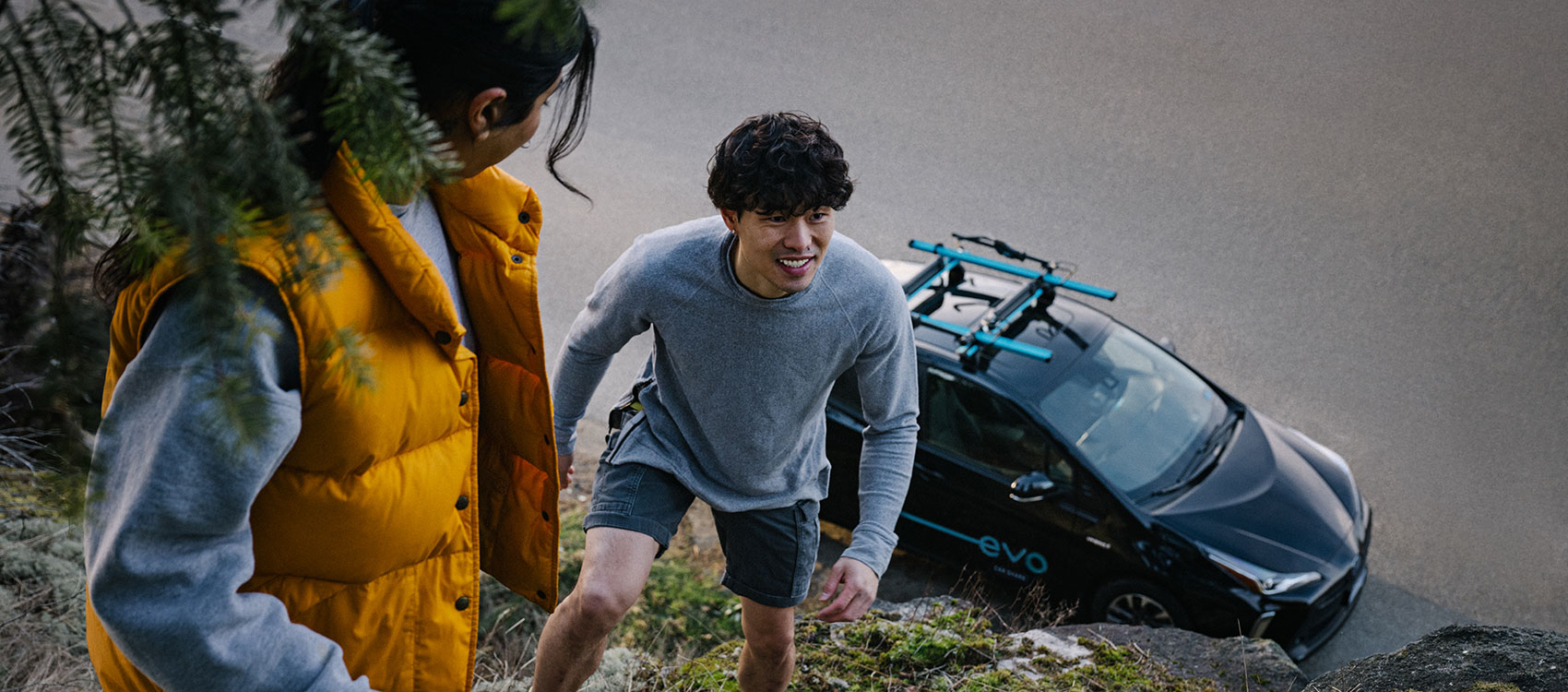 Couple starting their hike with an Evo car parked nearby