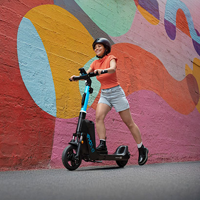 Girl on an Evolve e-bike in front of street art