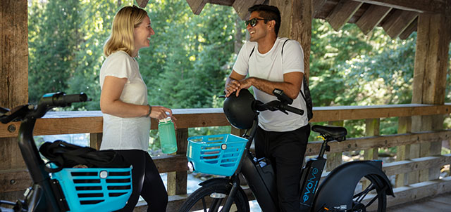 Man and woman on wooden bridge with e-bikes