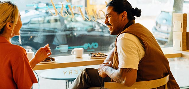 Two people chatting in a cafe window
