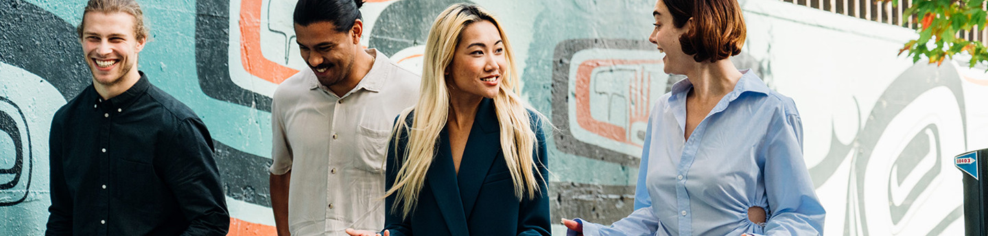 Group of four people walking in front of a street mural